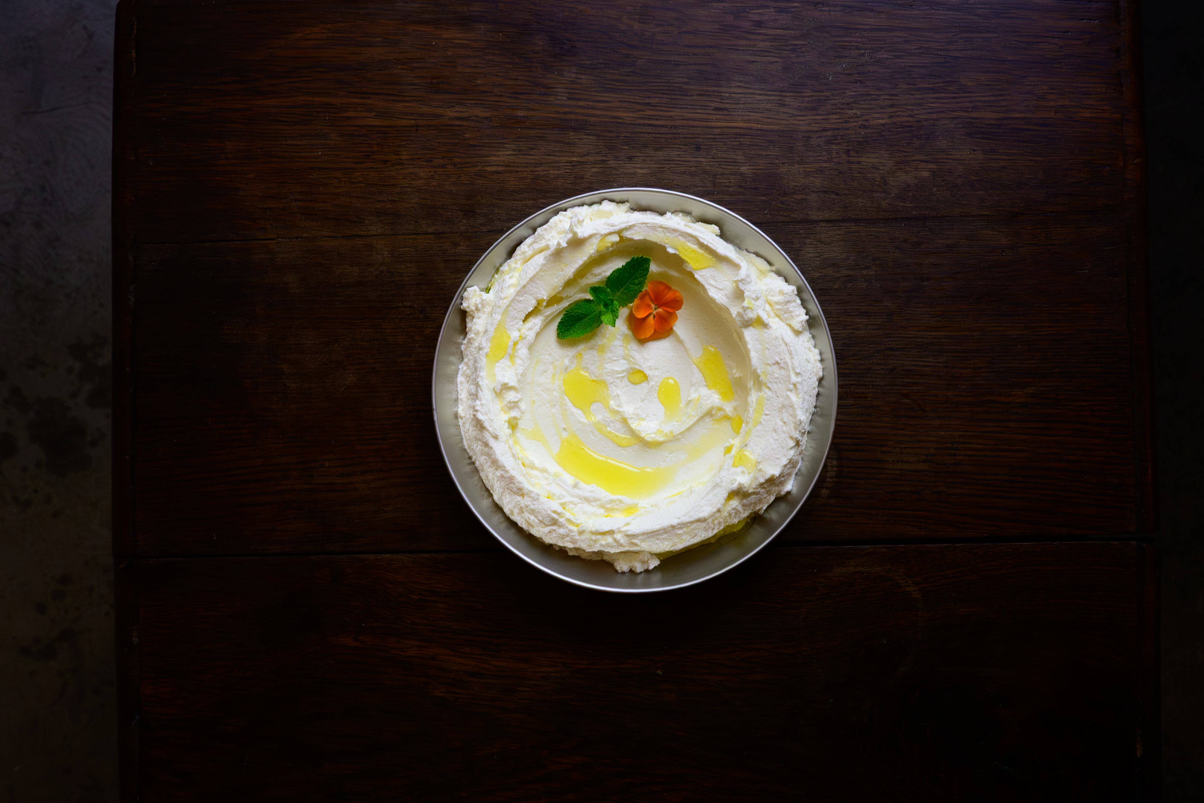 A refined restaurant dip photographed on a dark wooden table