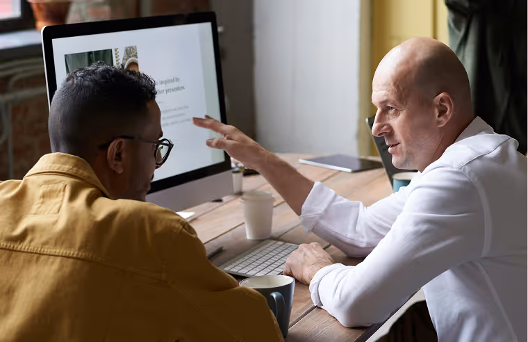 Two men talking in front of a screen
