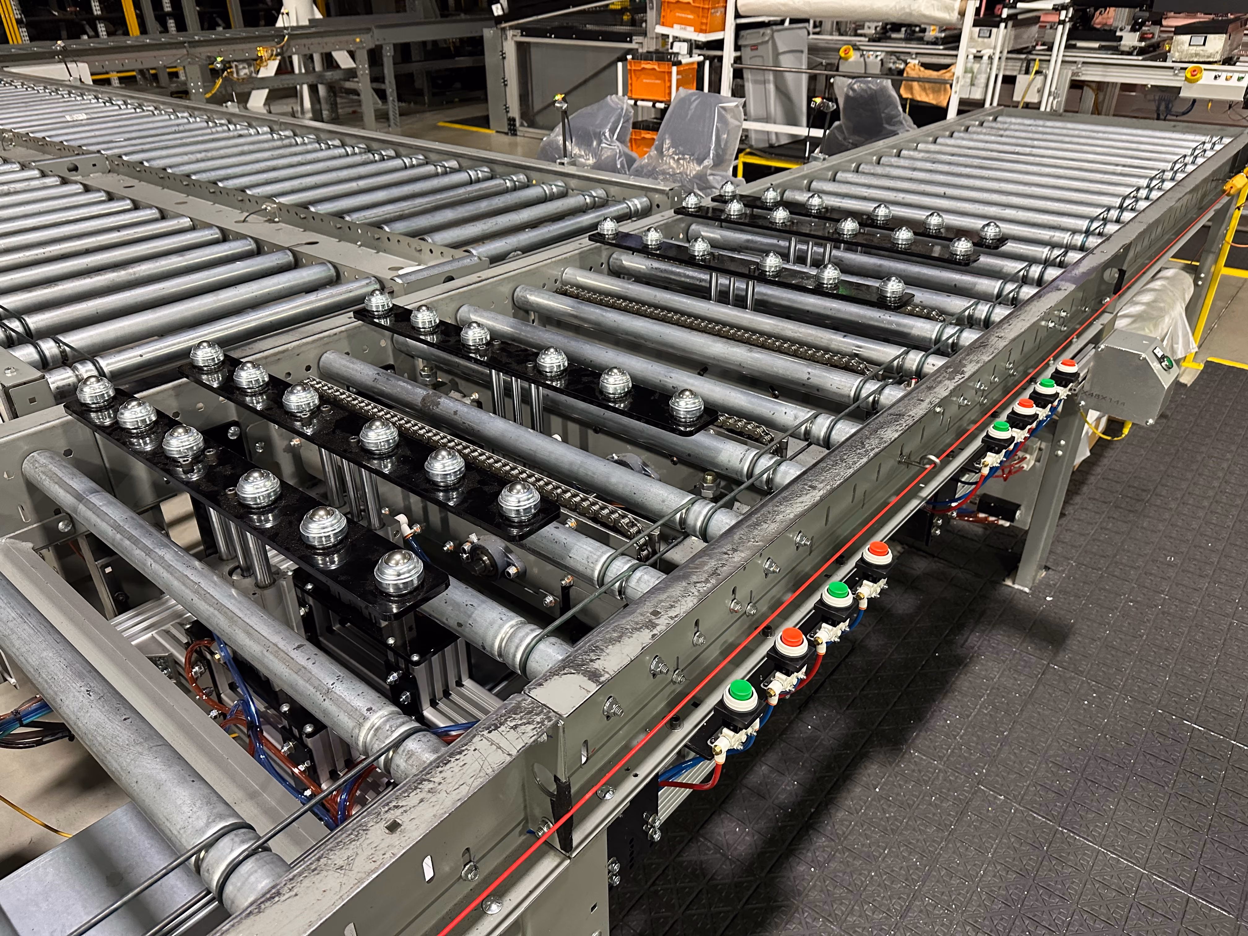 Close-up of a roller conveyor system with pneumatic diverters and control buttons