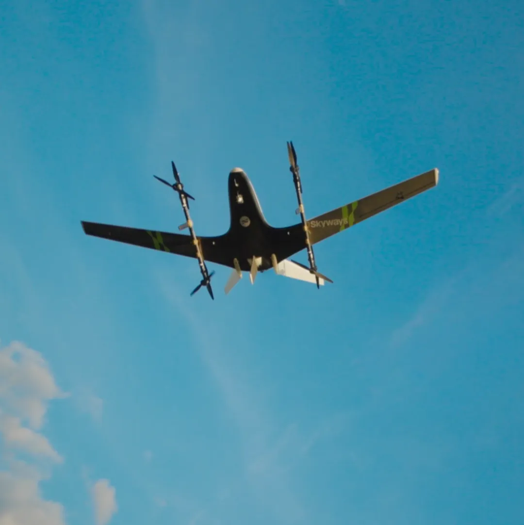 Electric vertical takeoff and landing aircraft flying against a blue sky.