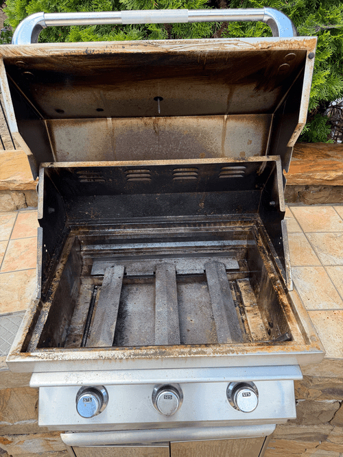 Built-in grill with heavy grease and rust before cleaning