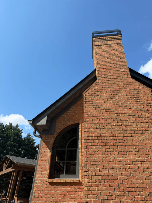 Chimney fascia boards with worn paint before repainting