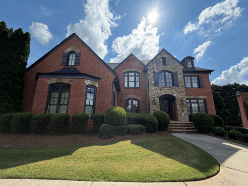 Front elevation of the brick and stone home at 2420 Concord Creek Trail in Cumming, Georgia