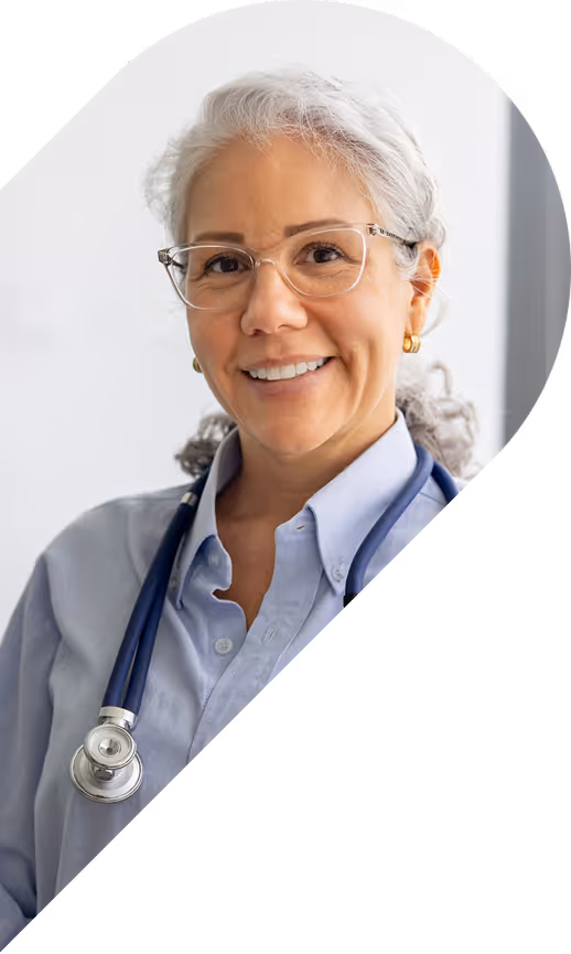 Smiling female doctor with gray hair, glasses, and a stethoscope around her neck.
