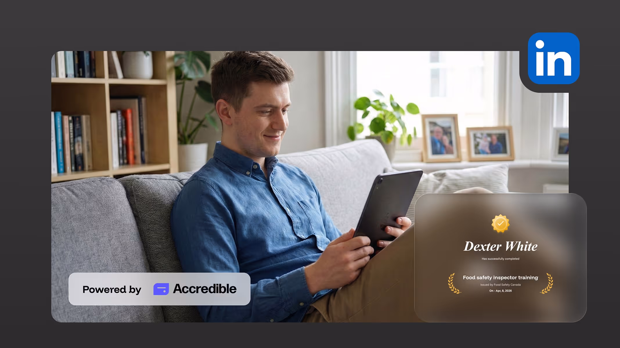 Man sitting on a sofa holding a tablet with a digital certificate for food safety inspector training.