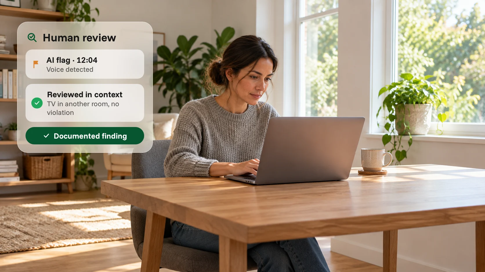 Person taking an online exam at a laptop in a bright home study, with an AI flag for a detected voice reviewed in context by a person and recorded as a documented finding with no violation.