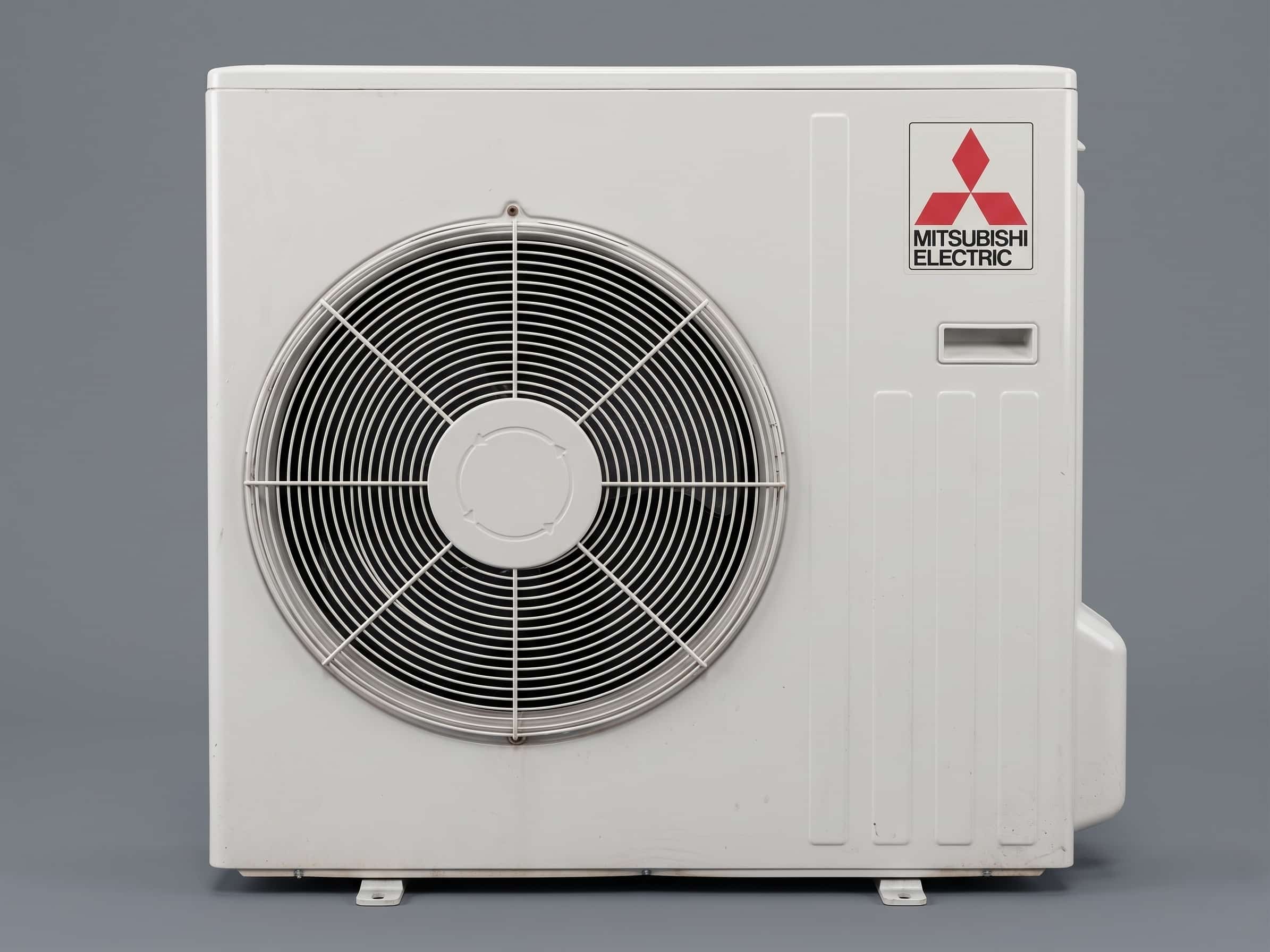 Mitsubishi Electric outdoor heat pump unit showing the three-diamond logo and brand name on the casing