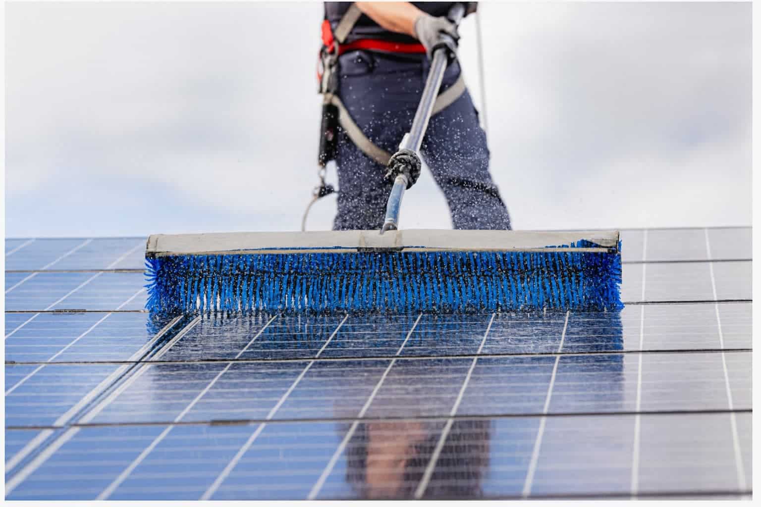 Person washing solar panel as part of a maintenance plan.