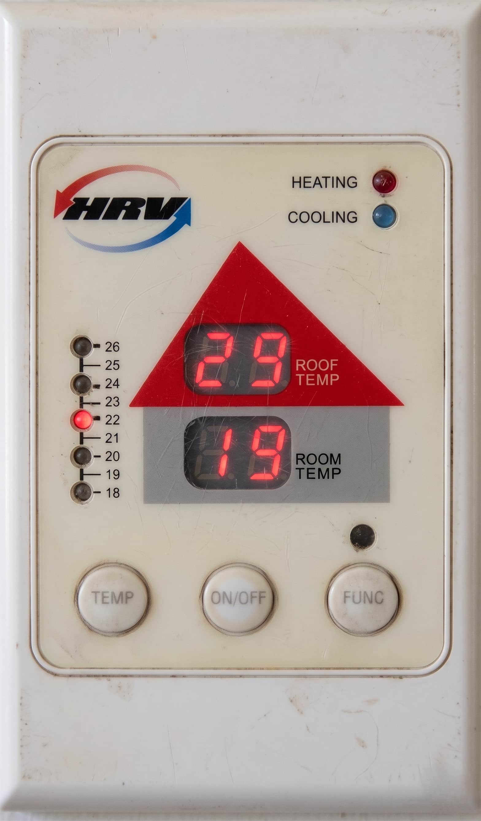 Old HRV wall controller showing roof temperature of 29 degrees and room temperature of 19 degrees, mounted on a white wall.