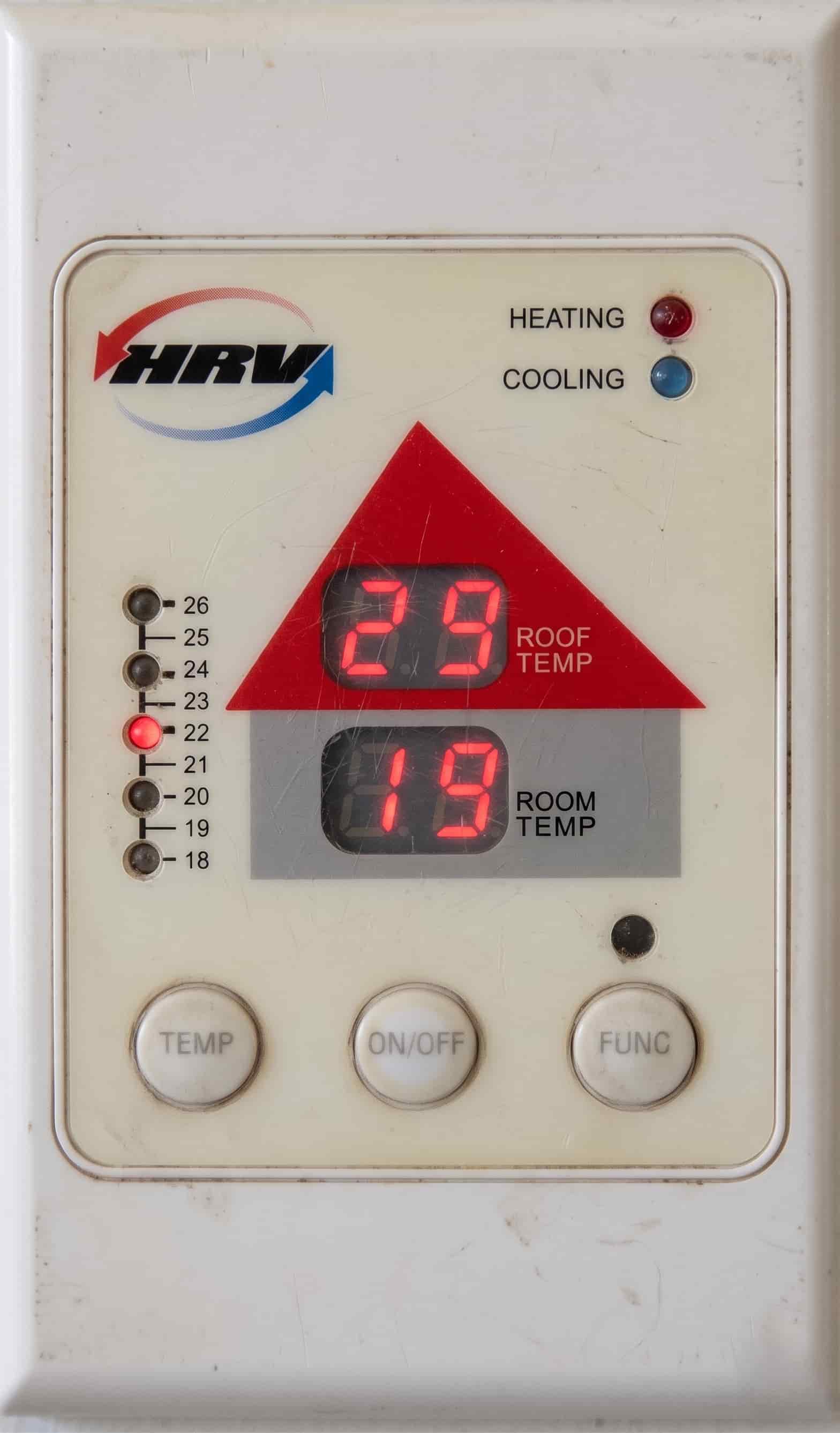 Old HRV wall controller showing roof temperature of 29 degrees and room temperature of 19 degrees, mounted on a white wall.