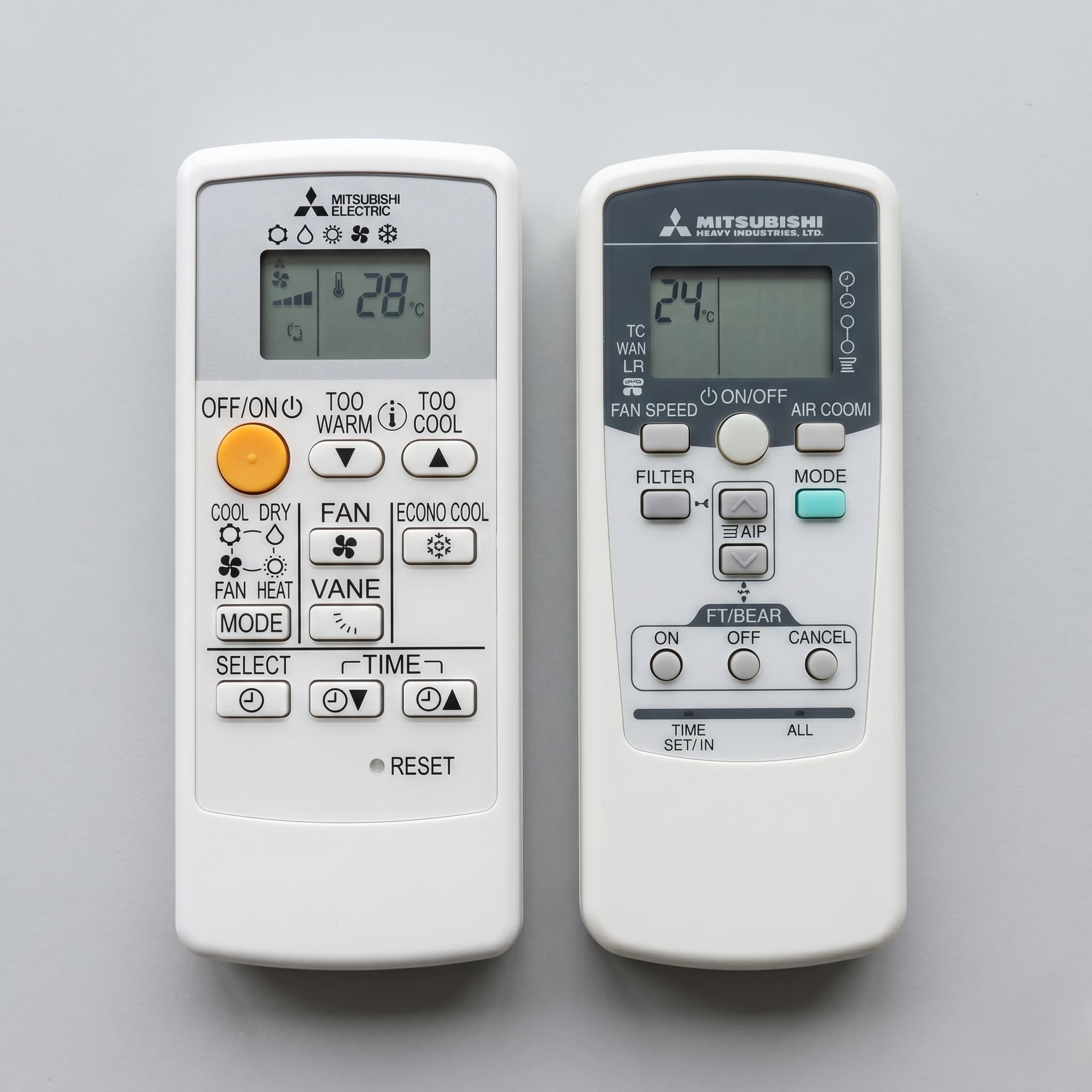 Mitsubishi Electric and Mitsubishi Heavy Industries heat pump remotes side by side showing different button layouts and branding