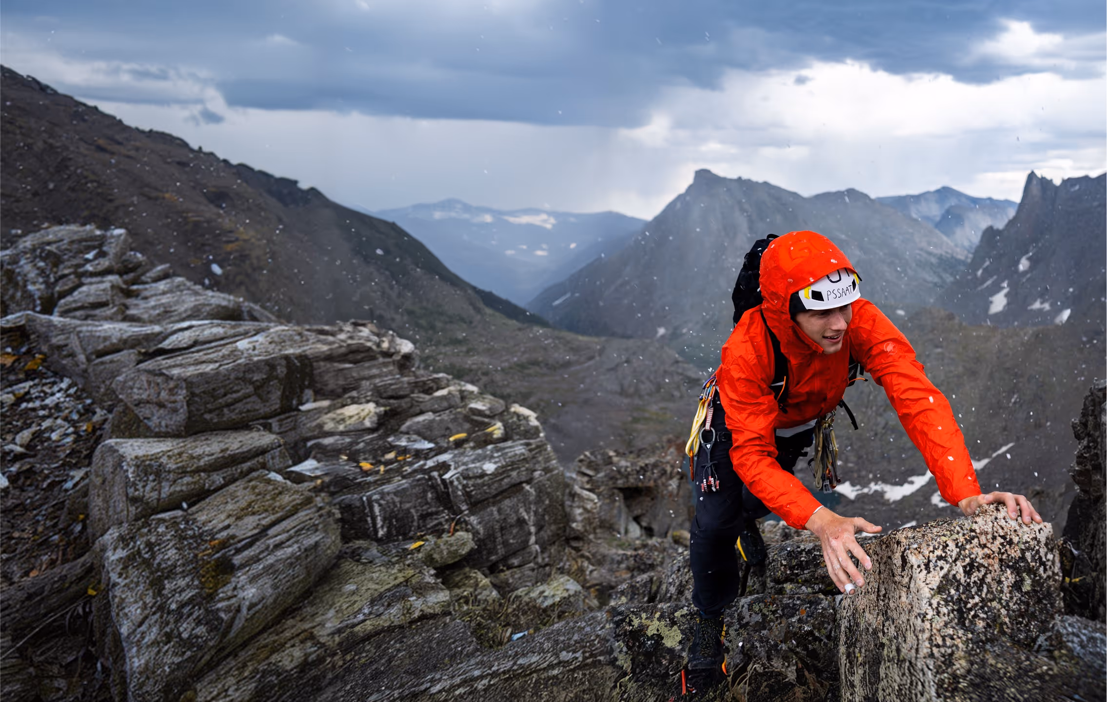 A climber navigating a steep rocky face using hands and feet on an alpine rock climbing route