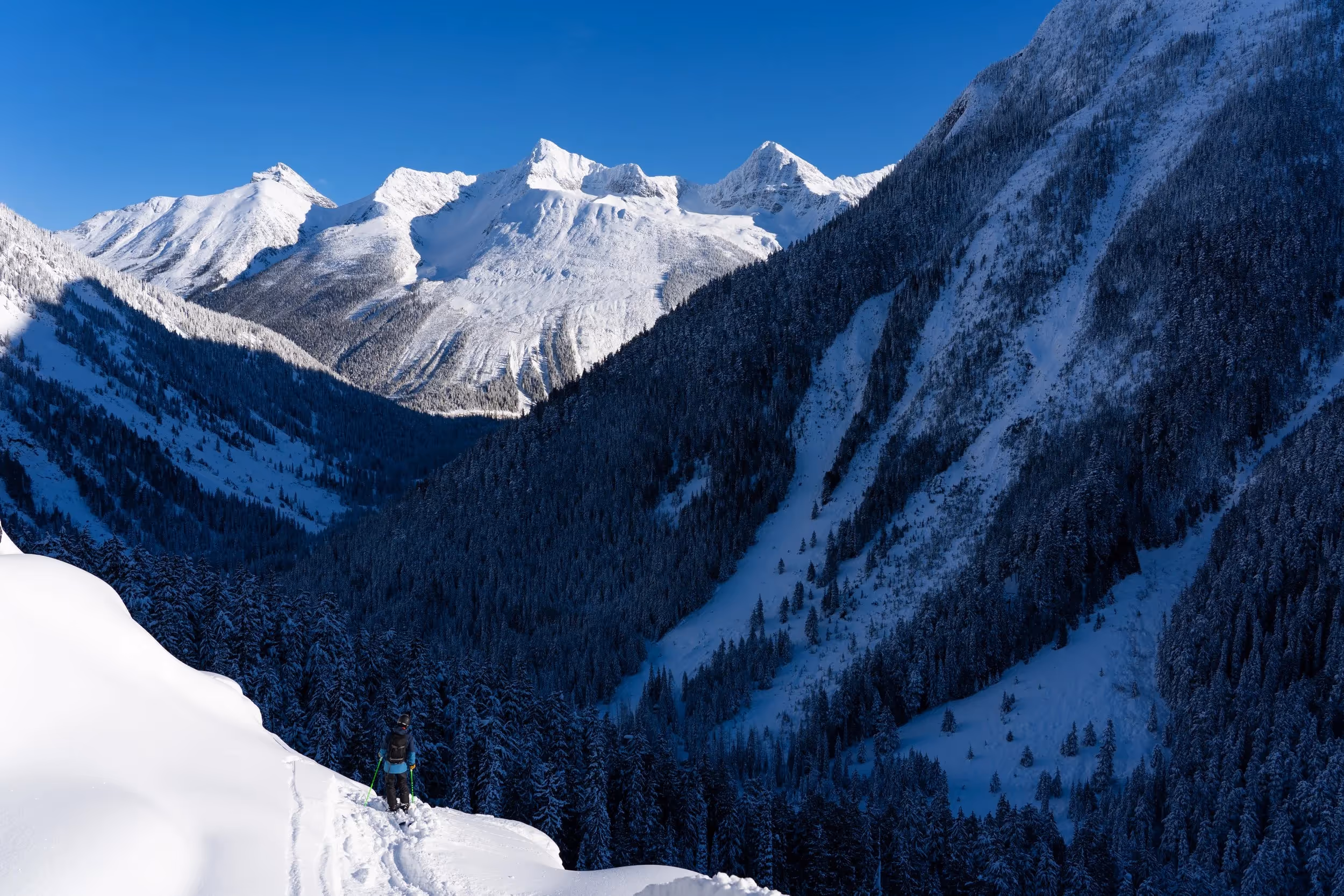 A climber practicing ice axe or crampon techniques on a steep snow slope during a mountaineering skills course