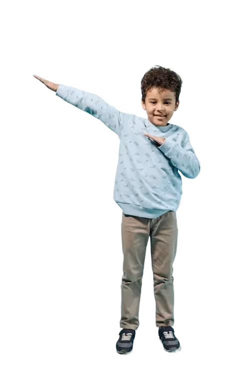 Young boy in a light blue sweater and beige pants posing with arms extended in a dab gesture.