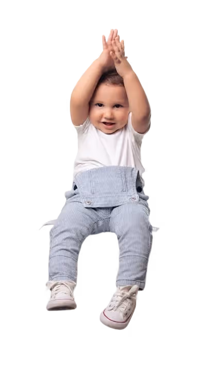 Smiling baby with arms raised, wearing a white shirt and striped overalls.