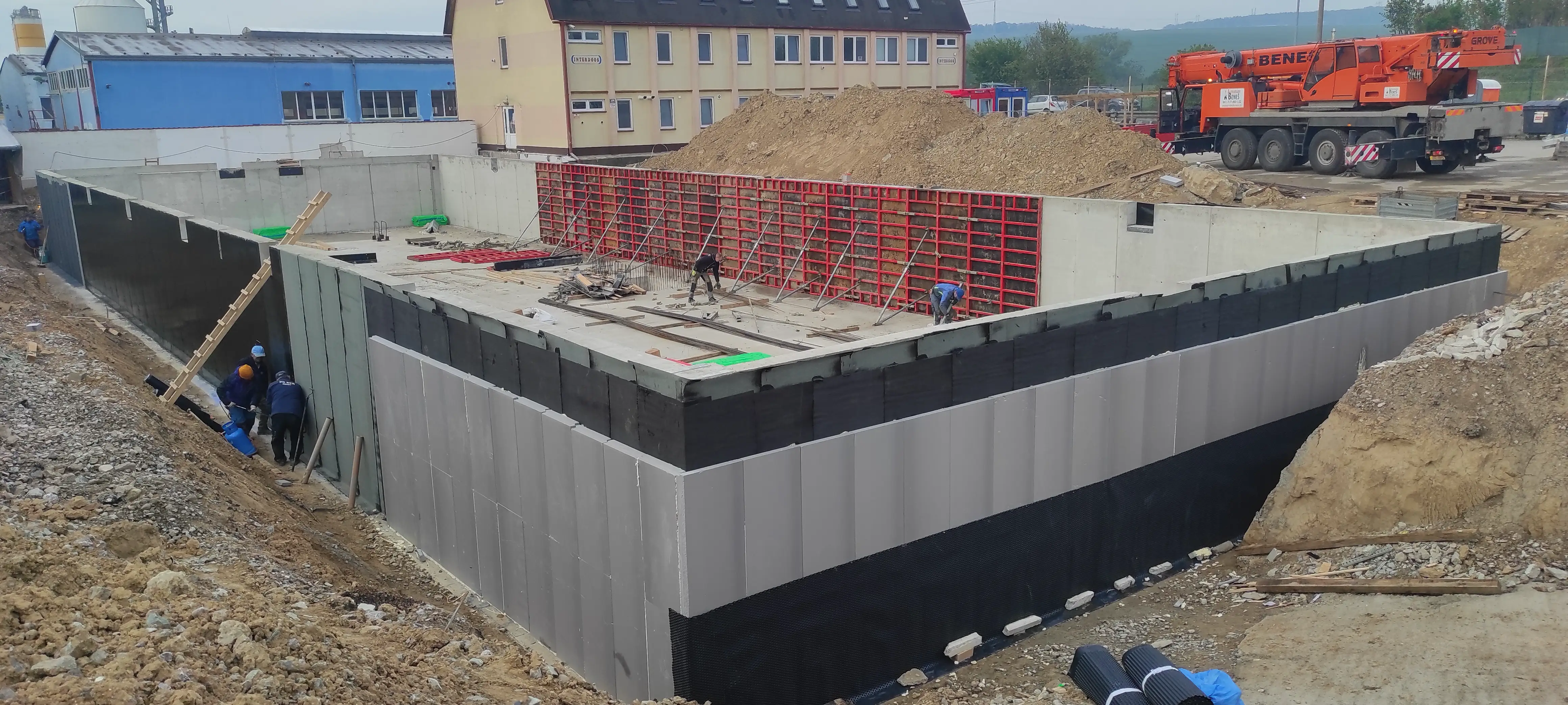 Usazování střešních vazníků pomocí jeřábu při realizaci hrubé stavby z cihel
