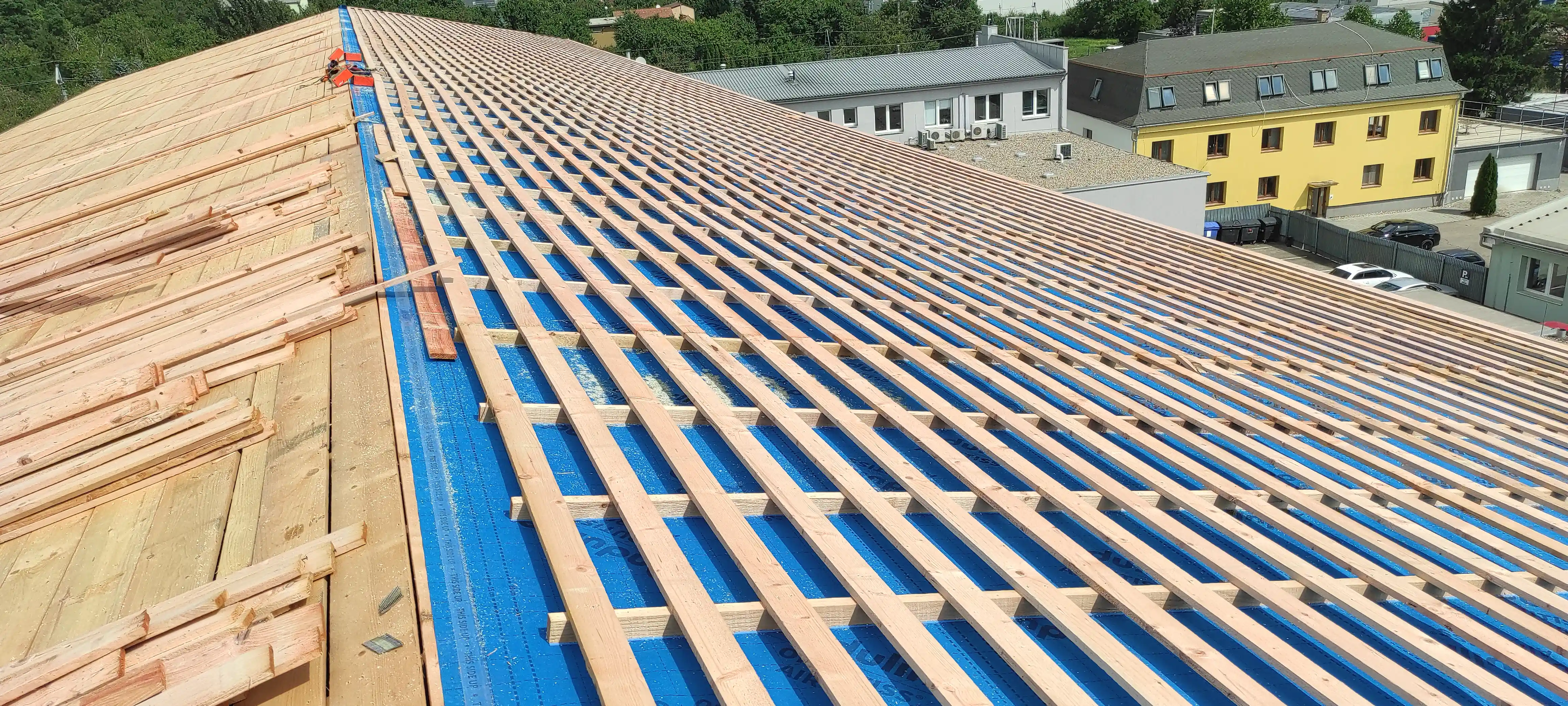Dřevěný krov a střešní konstrukce rozestavěného domu během probíhající stavby