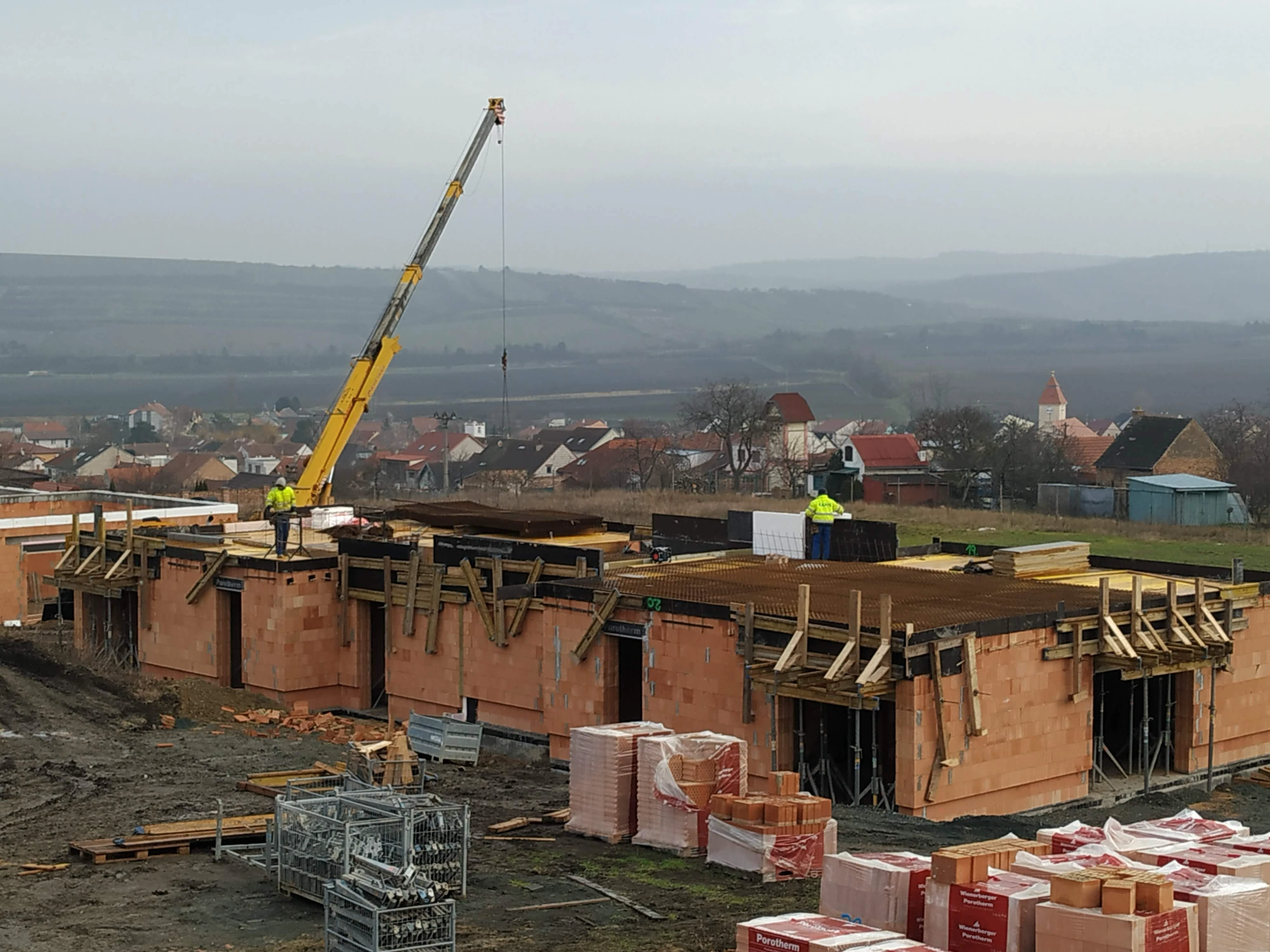 Dřevěný krov a střešní konstrukce rozestavěného domu během probíhající stavby