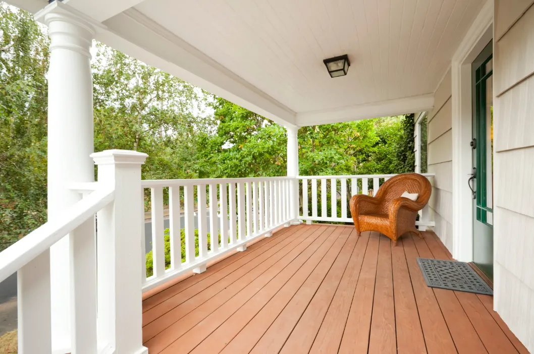 A bright and cozy front porch with a wicker chair looks inviting, showing the importance of insuring your home’s unique spaces with help from an independent insurance agency in South Florida.