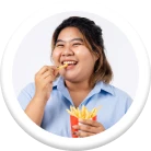 หญิงสาวยิ้มขณะกินเฟรนช์ฟรายส์ในถ้วยสีแดง