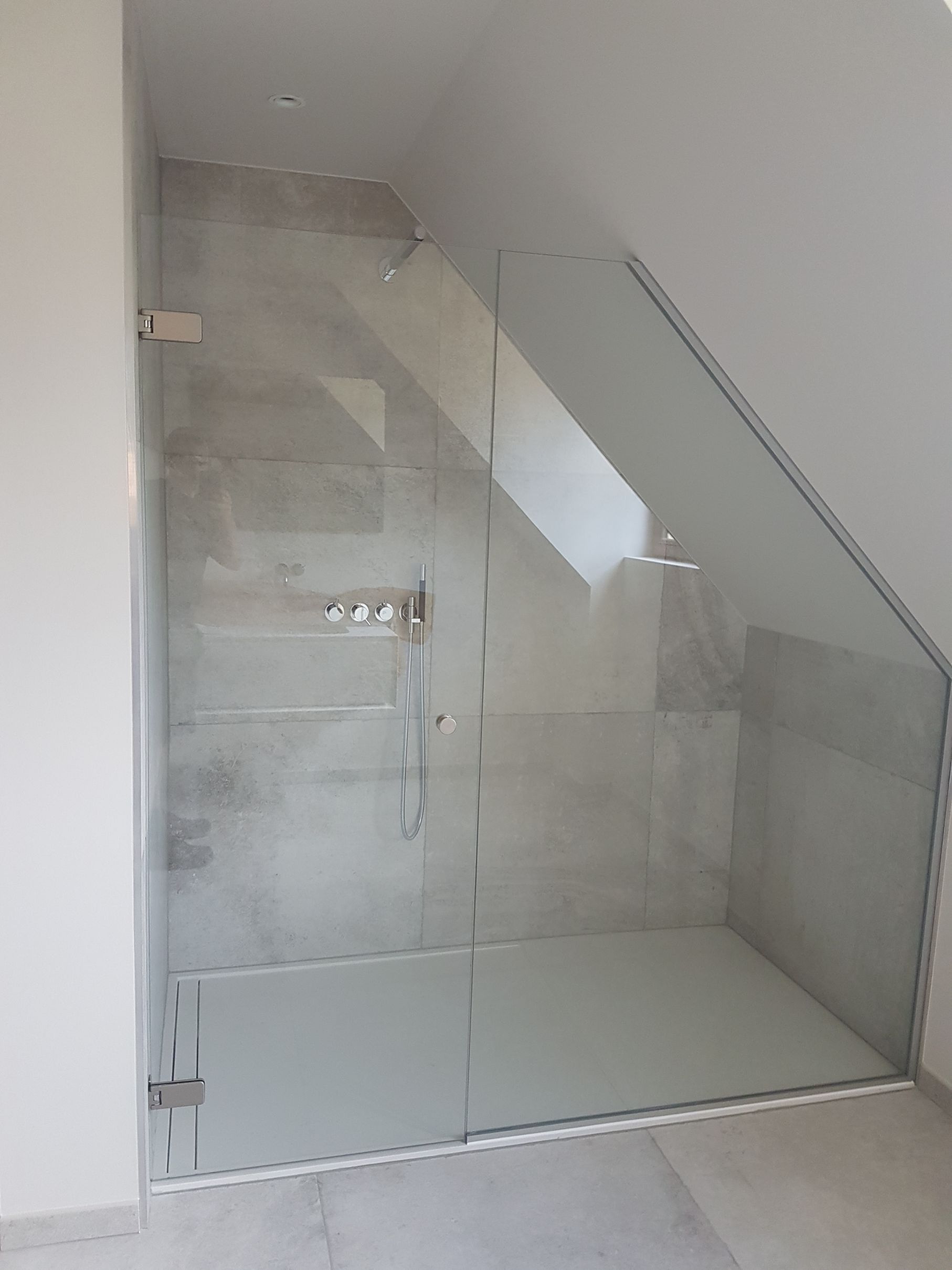 Badkamerrenovatie met inloopdouche onder schuin dak en glazen wand door Sanyvan