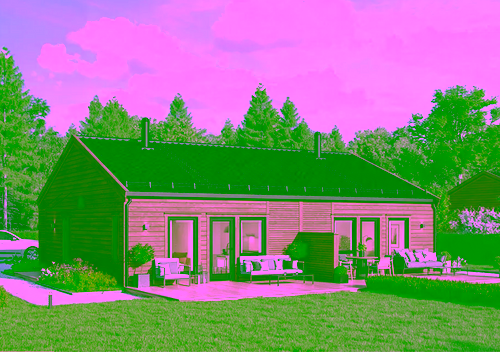 Moderne enebolig i tre med sort tak, stor gressplen og møblert terrasse under blå himmel med skyer.