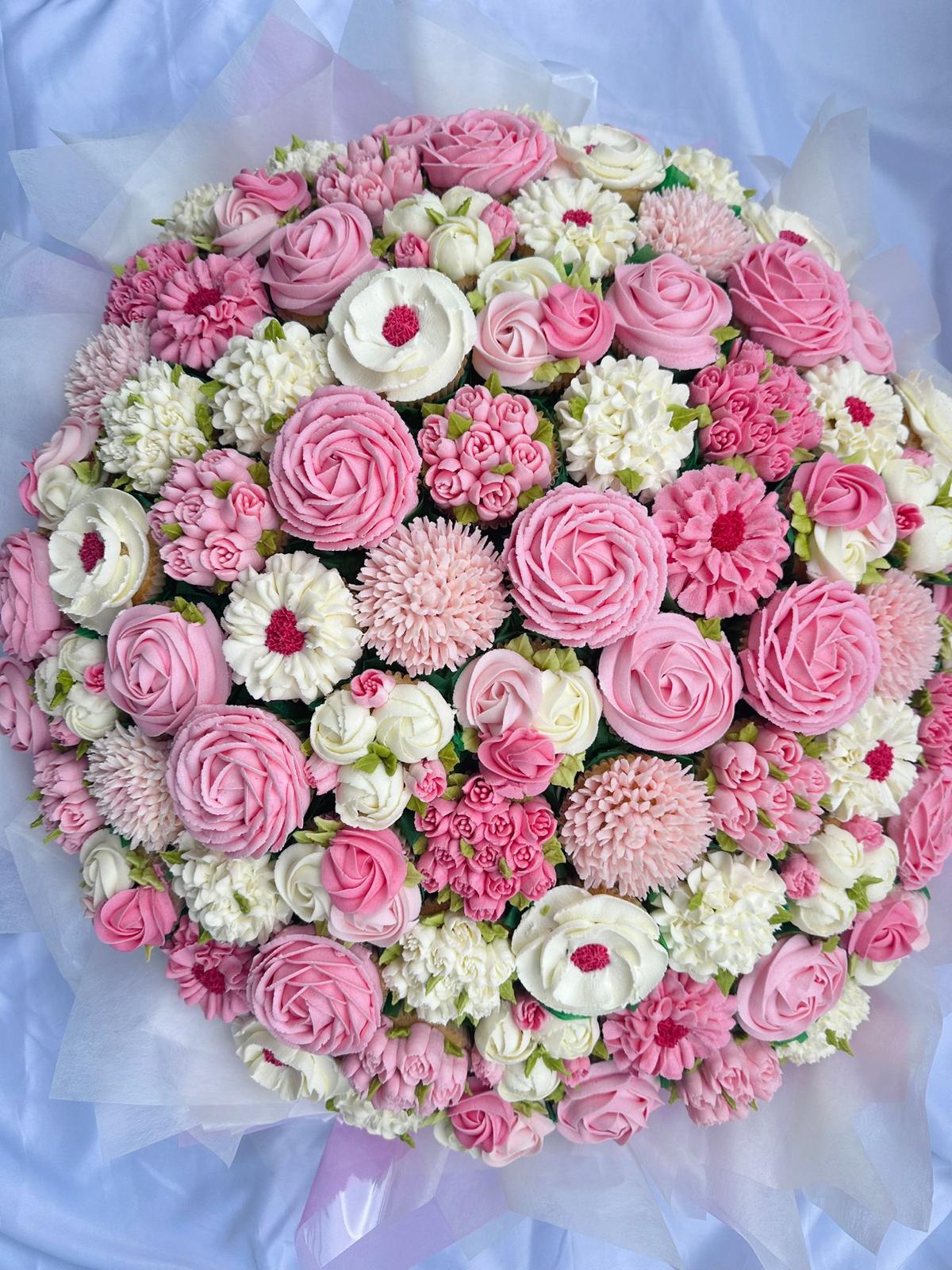Colorful bouquet of bright orange, yellow, and deep pink flowers wrapped in red and orange tissue paper.