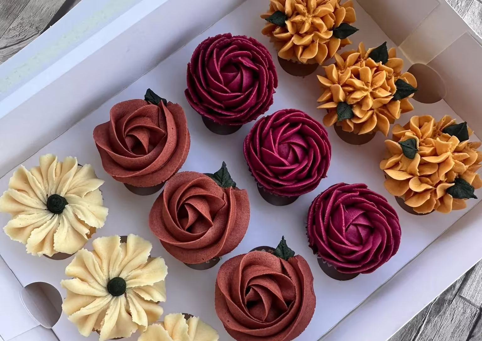 Coffret de cupcakes aux roses bordeaux et cuivre, marguerites crème et fleurs dorées