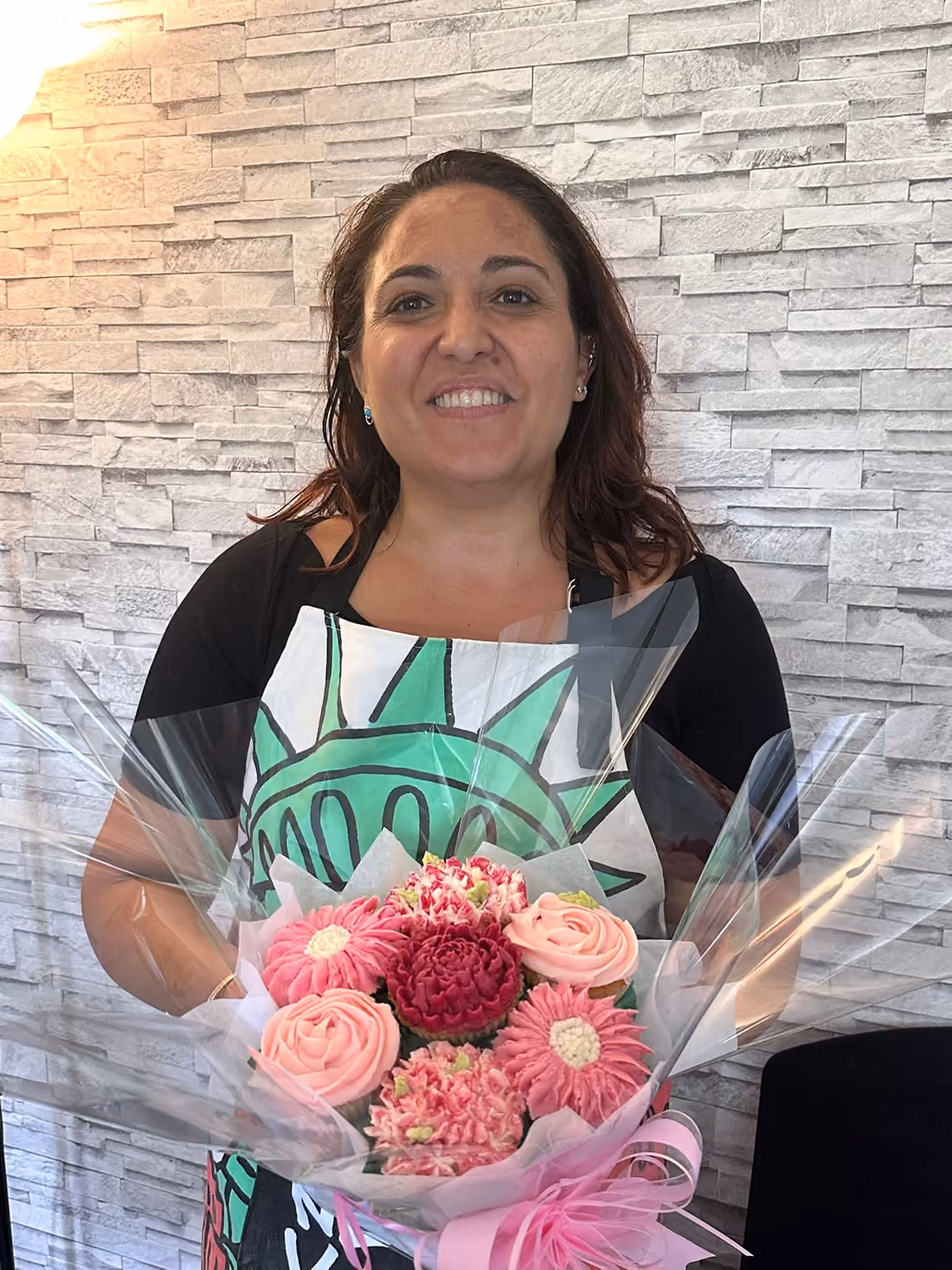 Participante de l'atelier fière de son bouquet de cupcakes roses
