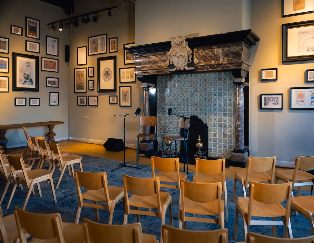 Empty room with rows of chairs facing chimmney