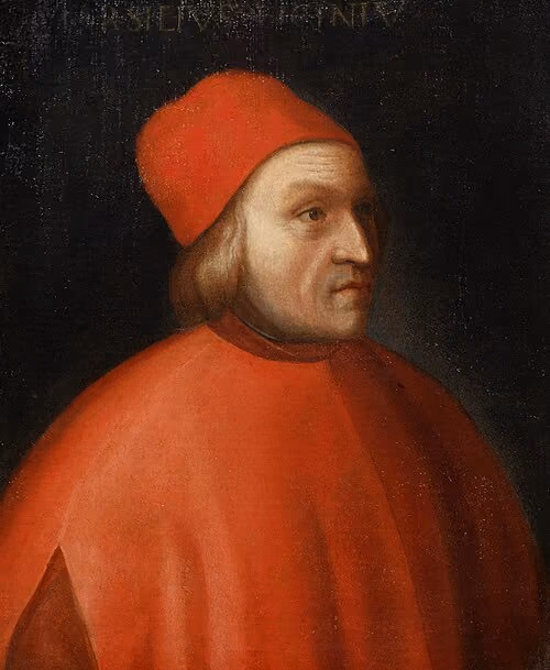 Portrait of Marsilio Ficino in a bright red cap and cloak against a dark background, looking toward the right.