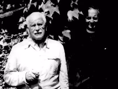 High-contrast black and white photograph of Carl Jung and Victor White standing outside together against ivy-covered leaves.