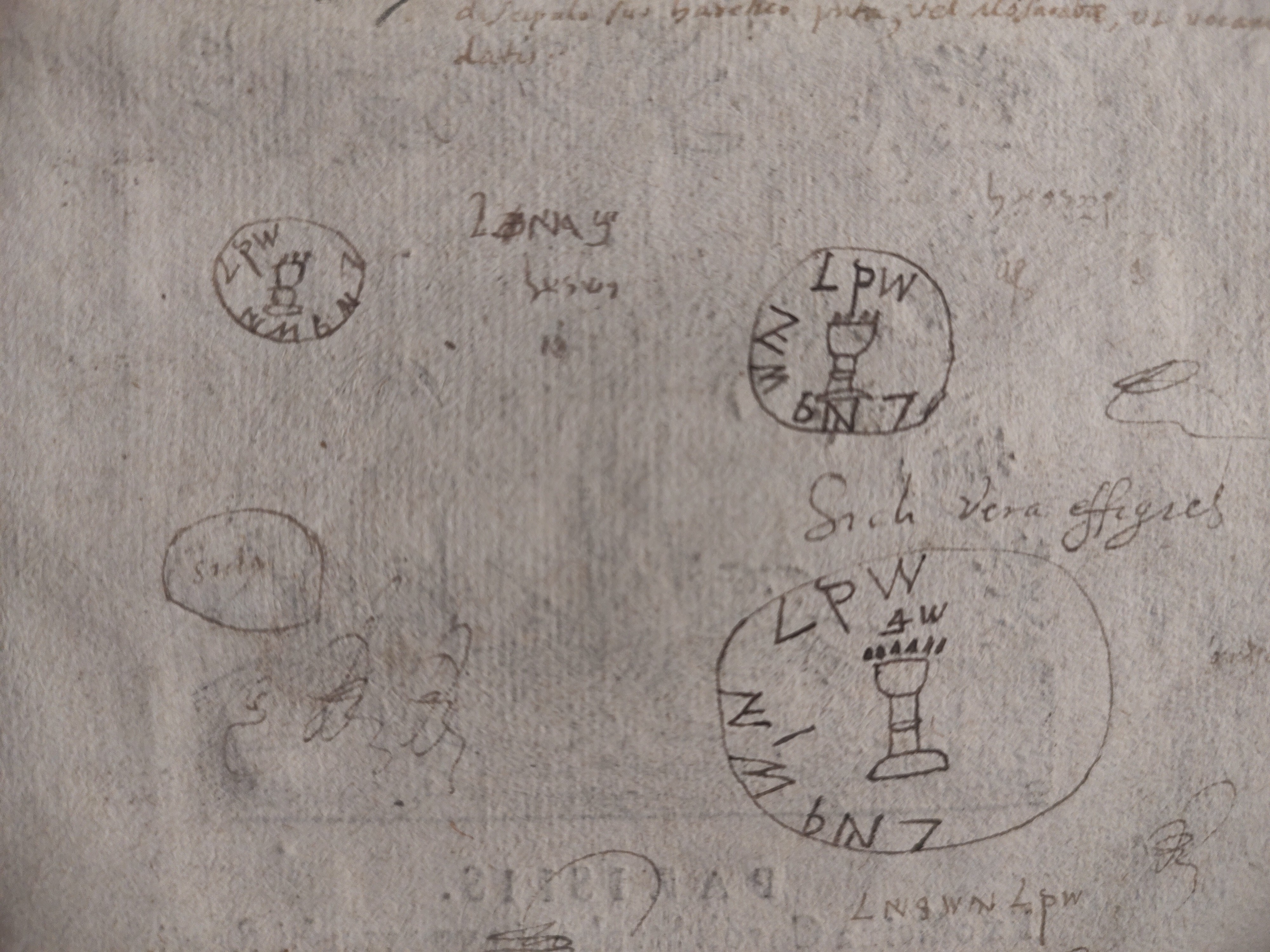 A close-up of aged, textured paper featuring several hand-drawn ink sketches of a circular coin or seal design.