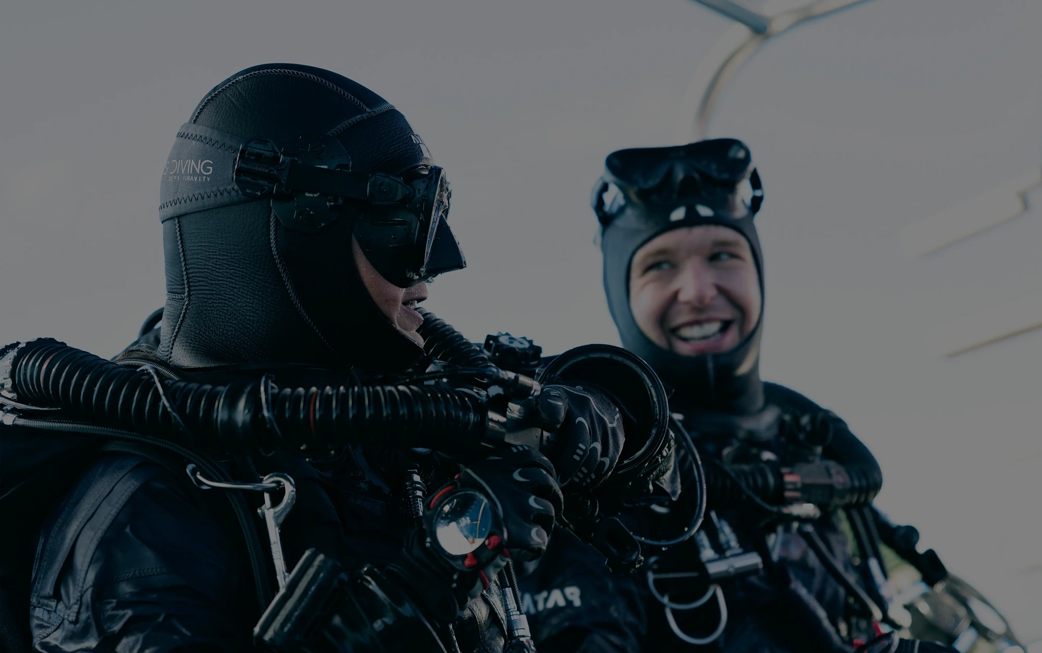 Two equipped divers preparing for a dive, smiling