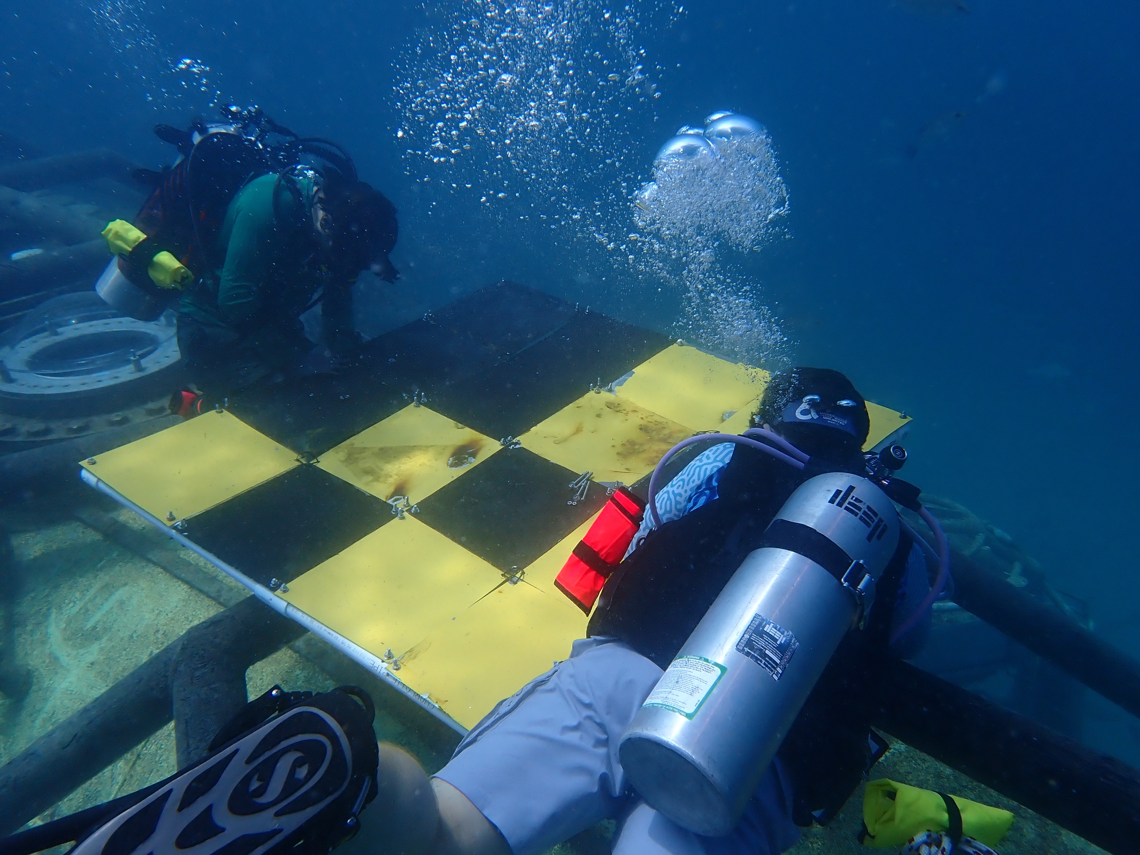 Divers installing settlement panels on Vanguard's exoskeleton
