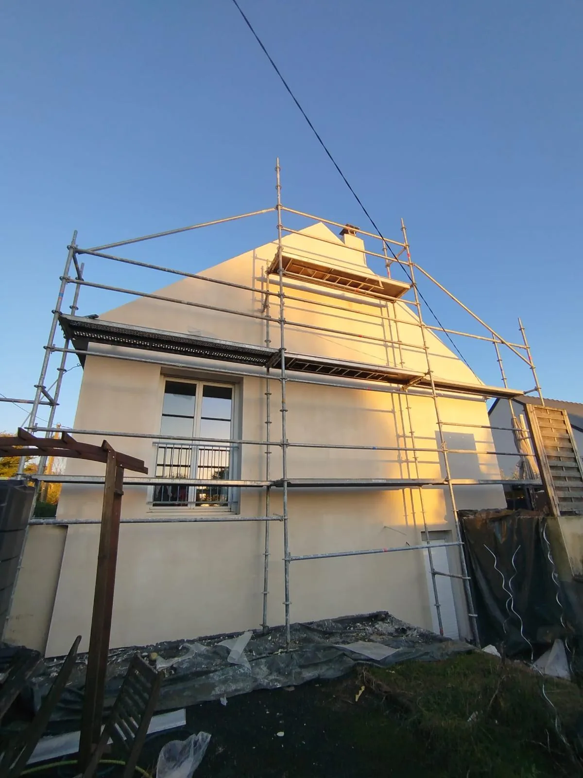 Chantier d'isolation thermique par l'extérieur sur une maison, enduit en cours
