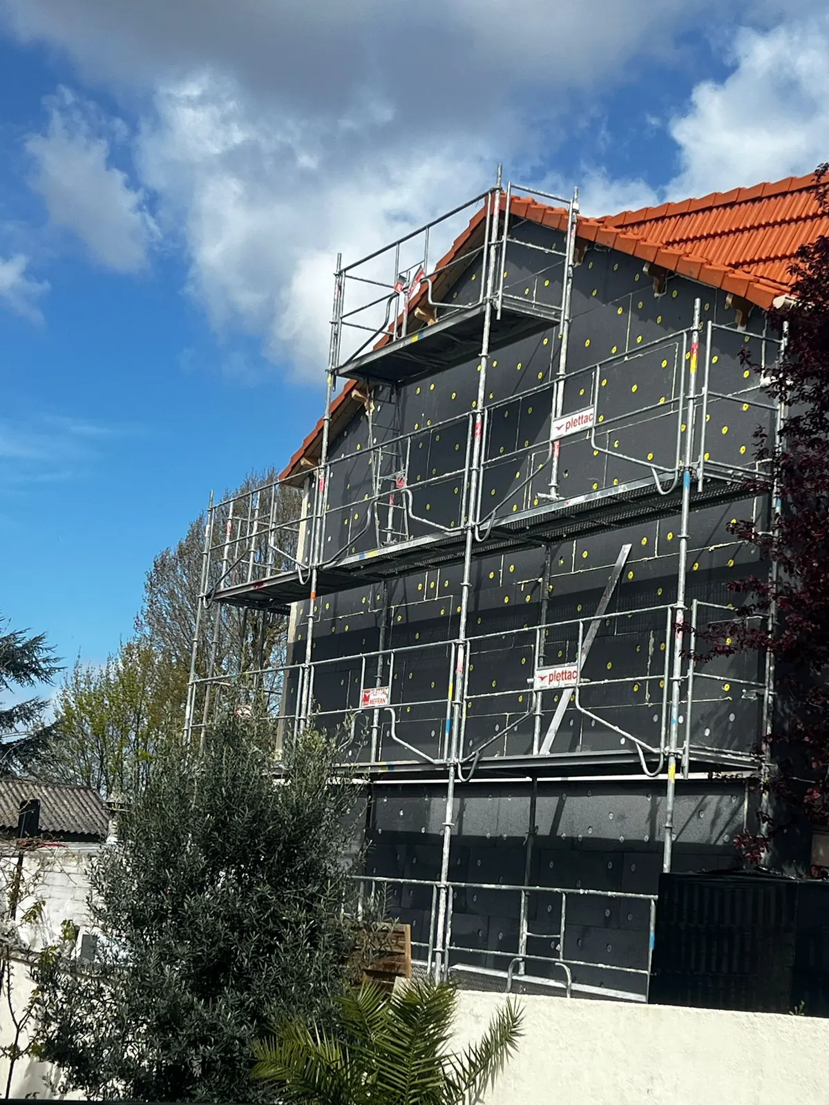 Chantier d'isolation thermique par l'extérieur MaBelleRénov : pose des panneaux isolants sur échafaudage
