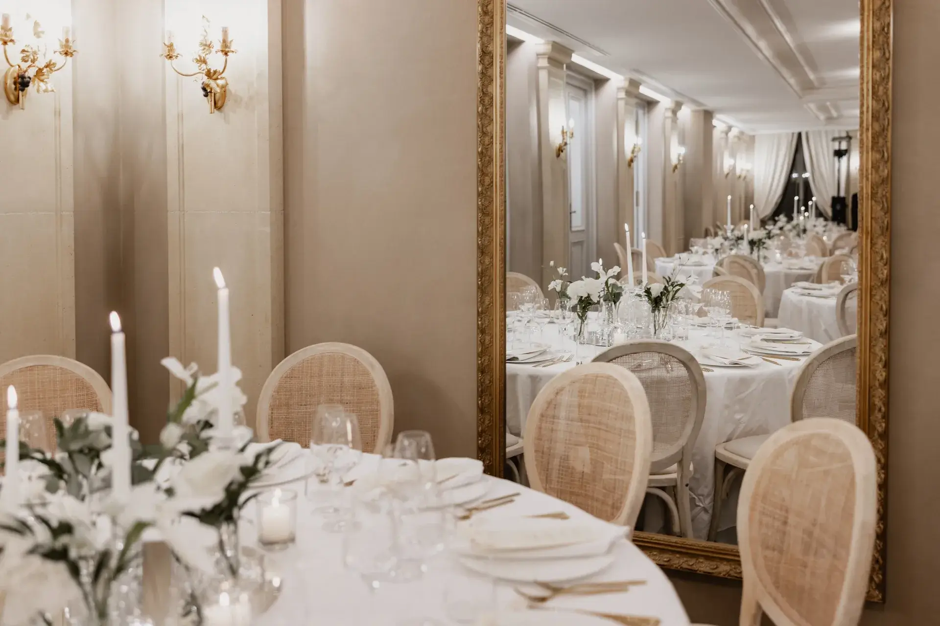 Eleganter Bankettsaal mit runden Tischen, weißen Tischdecken, Kerzen und Blumenarrangements.