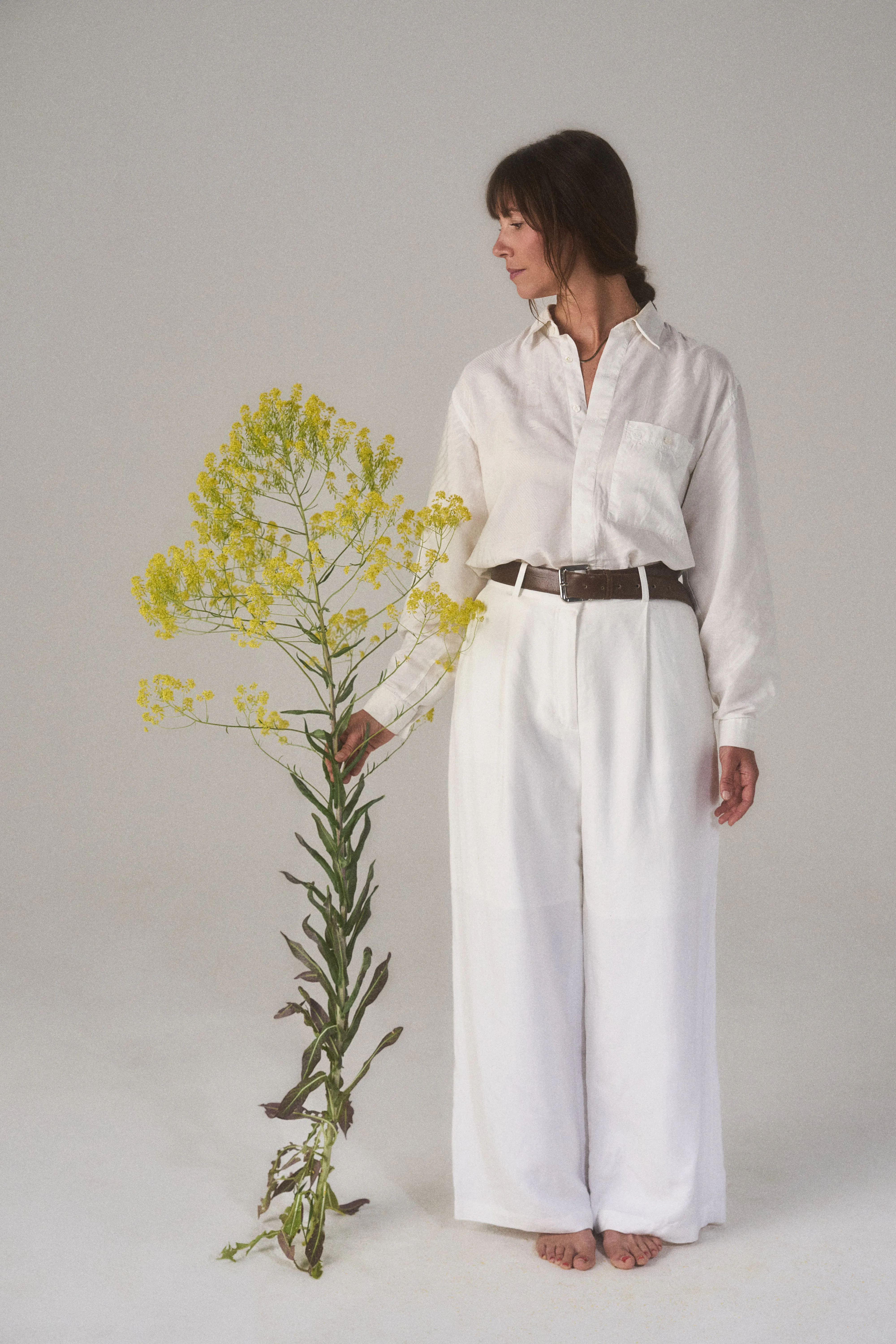 Bianca Gumbmann holding a tall flowering plant.