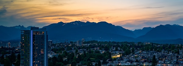 City skyline with mountains at dusk.