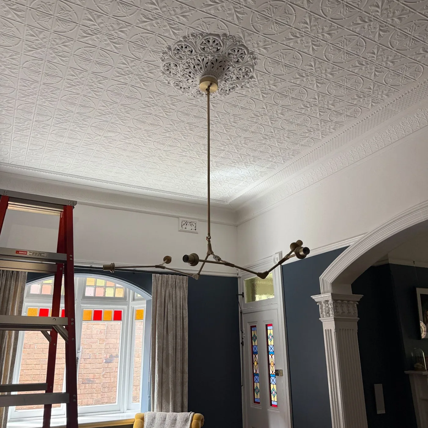 Feature pendant being installed on the ceiling rose in the sitting room