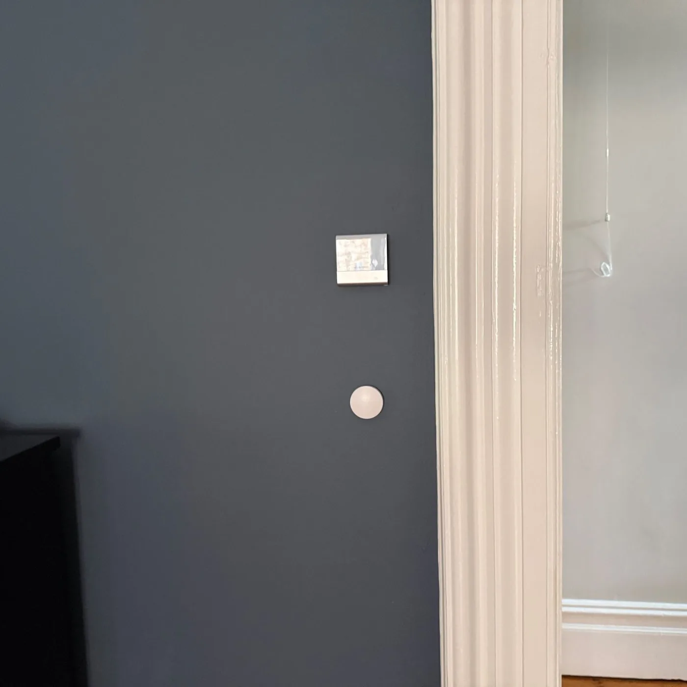 Wireless light switch on the wall beside the doorway