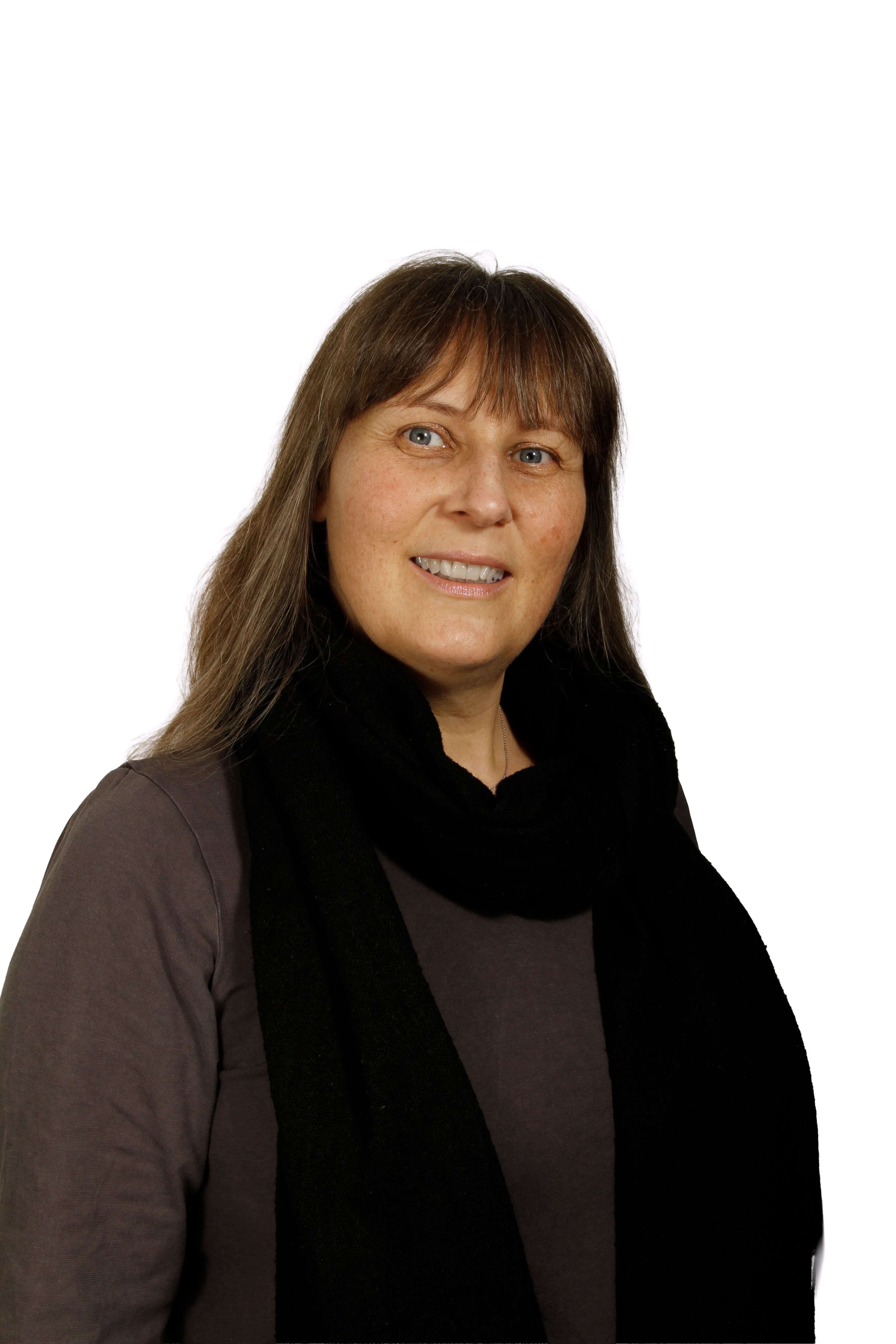 Smiling woman with long brown hair wearing a black scarf and brown top against a white background.