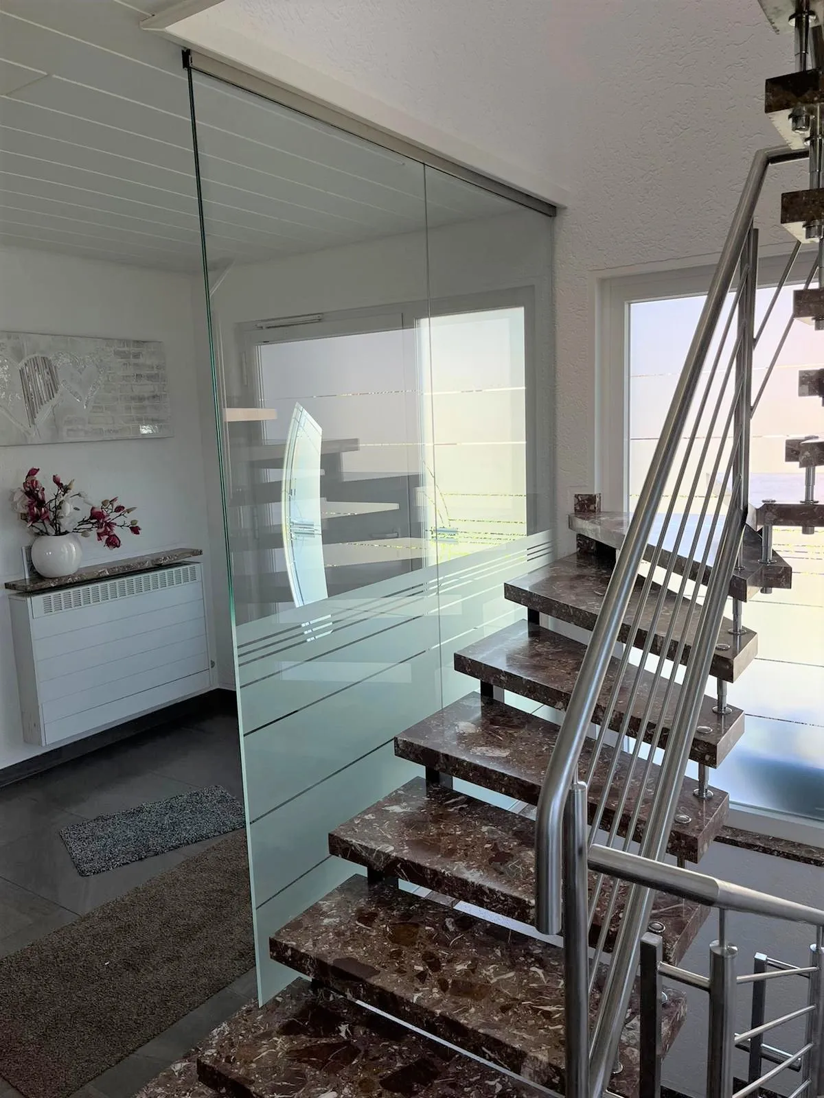 Stahltreppe innen mit Edelstahlgeländer und Glasfüllung