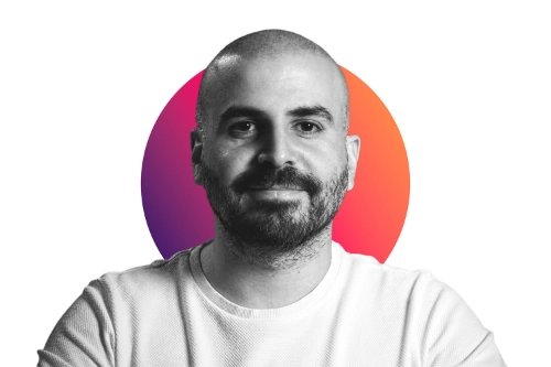 Porträt eines Mannes mit kurzem Bart und weißem Shirt vor einem kreisförmigen Farbverlaufshintergrund in Pink und Orange.