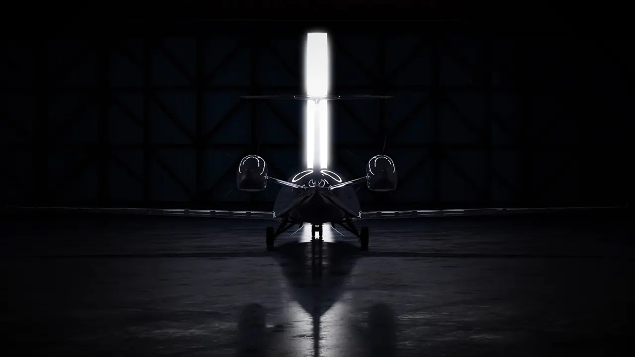 Vorderansicht eines Flugzeugs in einem dunklen Hangar mit Lichtstrahl hinter dem Schwanzflügel.