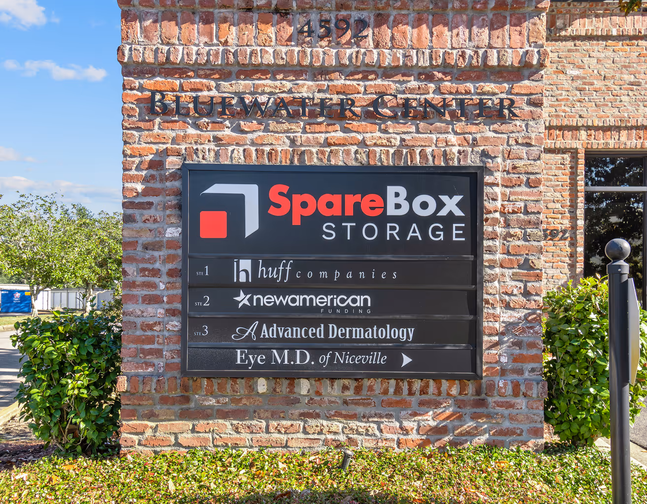 Brick sign for Bluewater Center with business listings including SpareBox Storage, Huff Companies, New American Funding, and Advanced Dermatology Eye M.D. of Niceville.