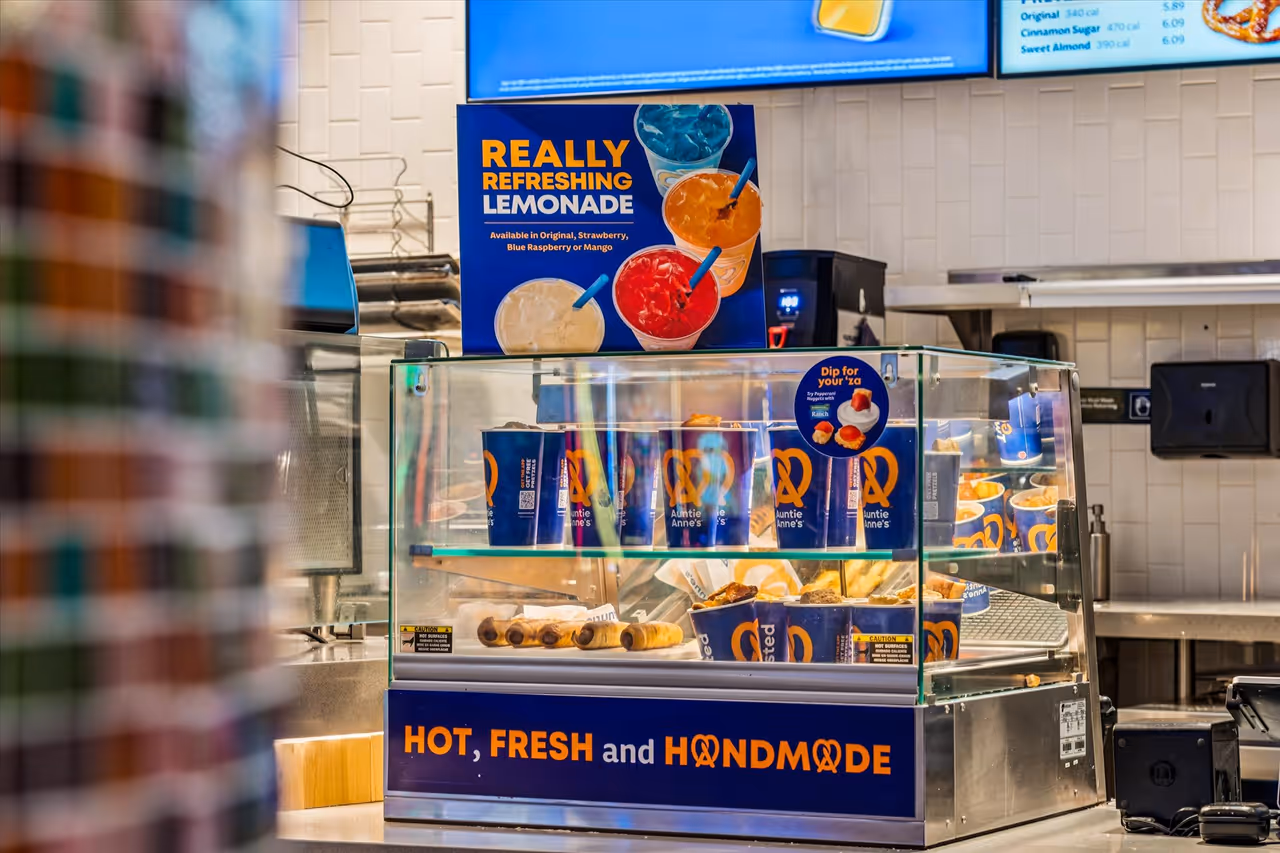 Display case at Auntie Anne's with pretzel products and a sign advertising really refreshing lemonade in various flavors.