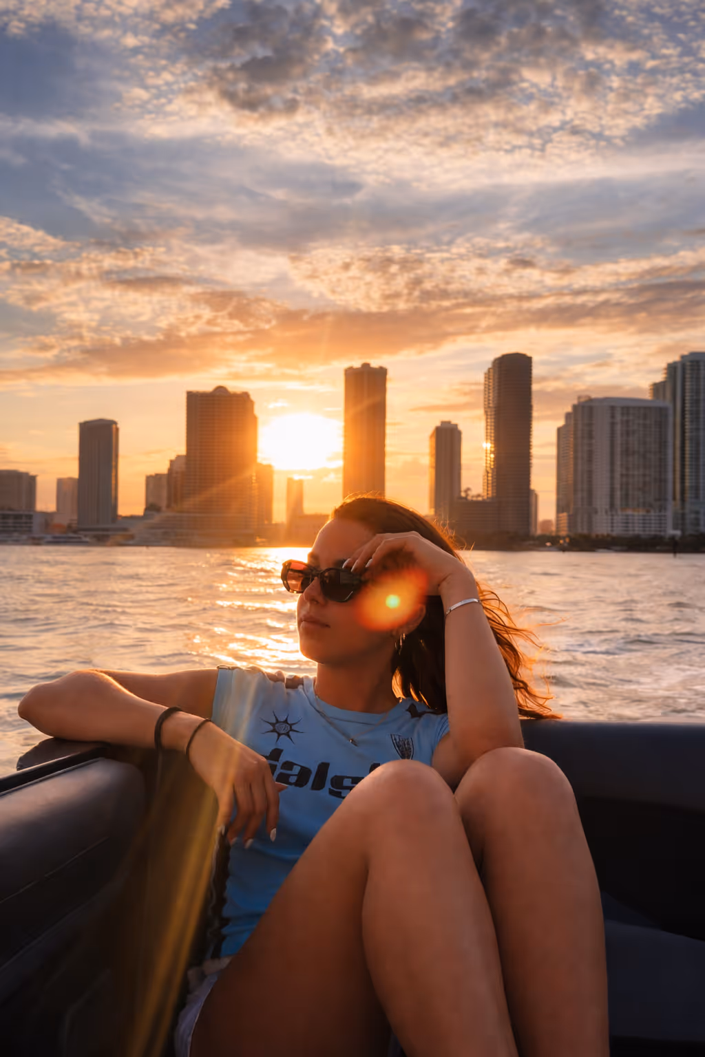 Lanchas a motor navegando en aguas turquesas con el horizonte de la ciudad al atardecer de fondo.