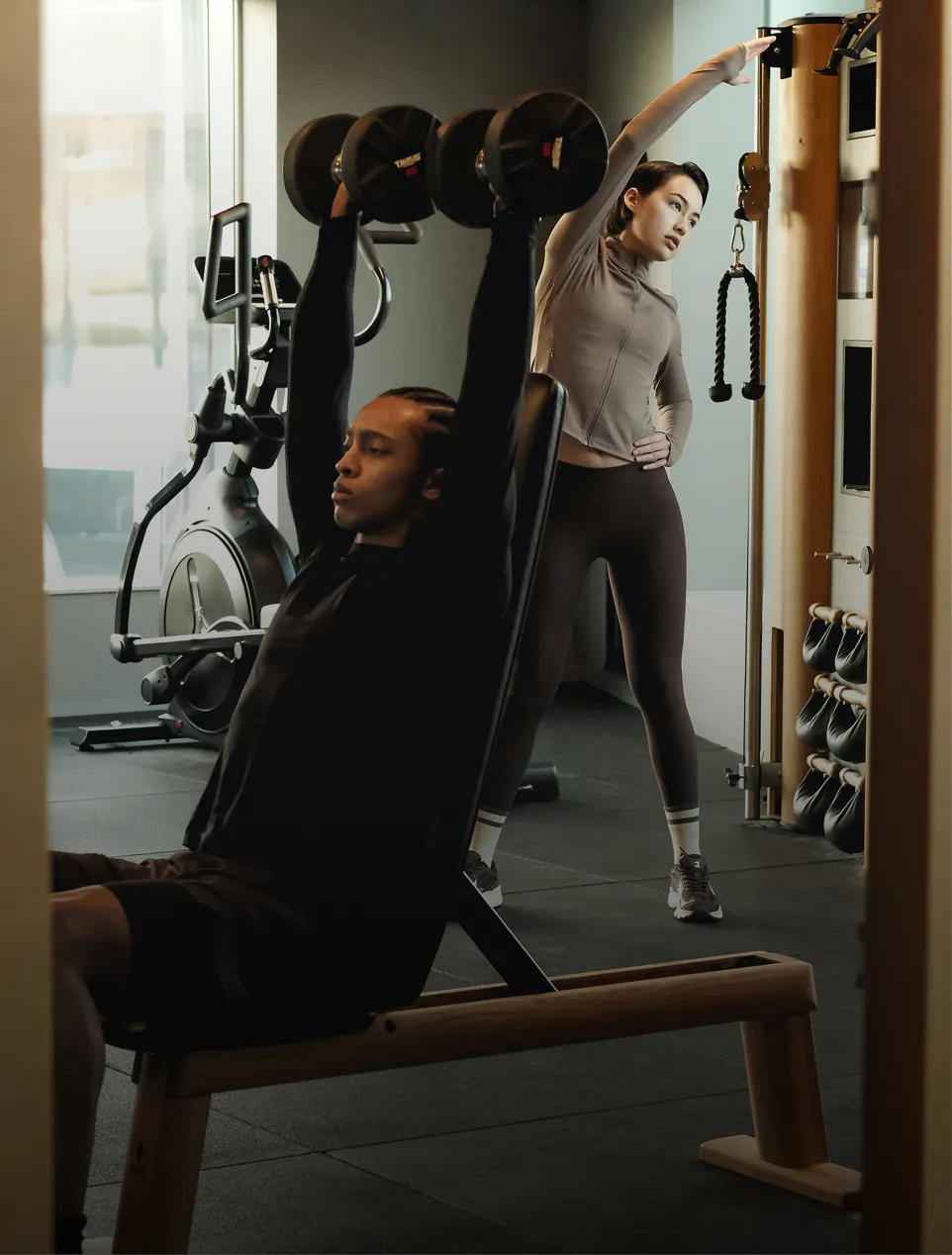 Two people sitting at a wooden table smiling and eating healthy meals with bread and lemon water, with text overlay 'Built around you. Nutrition Plans.'